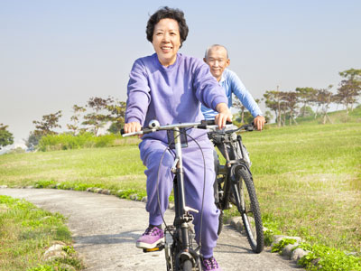 Senior couple riding bikes in the park