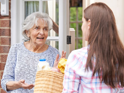 girl delivering groceries to senior woman